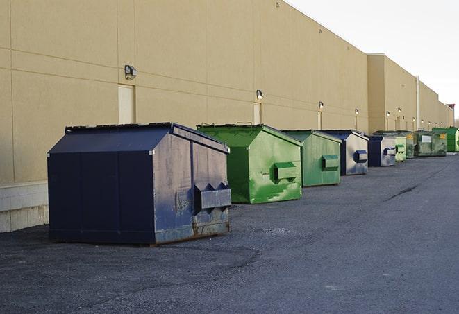 a fleet of red and blue construction dumpsters available for use in Canal Point